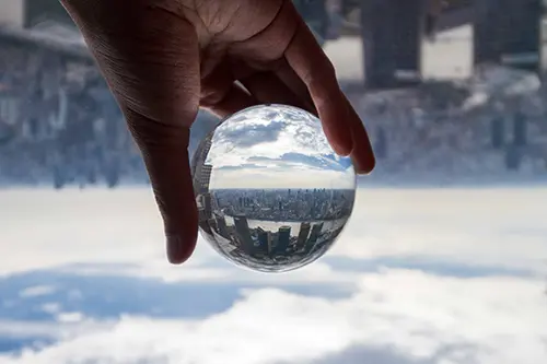 Hand holding a glass ball showing the landscape of Shanghai