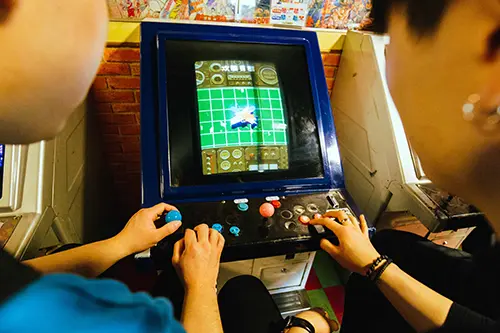 Two people play an arcade game