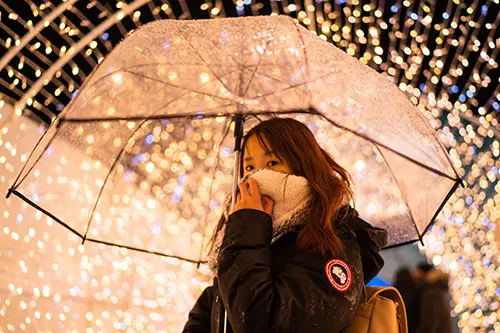 Person under a clear umbrella under LED lights
