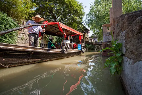 Traditional Chinese boat travelling down a small river