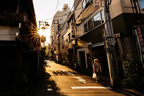 Woman walks through an alleyway during the sunset